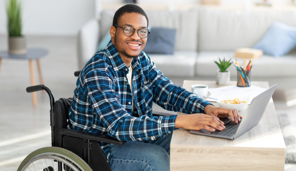 pessoa com deficiência na cadeira de rodas usando computador