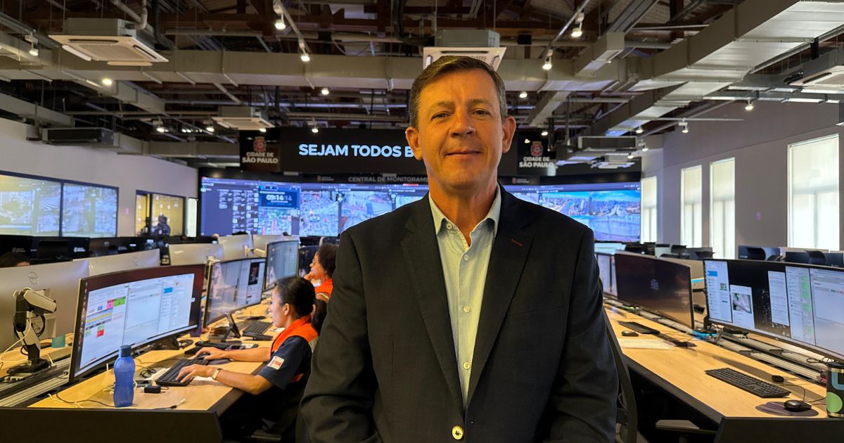 Orlando Morando, secretário de Segurança Urbana de São Paulo, posa na Central de Monitoramento do Smart Sampa, com operadores e telas ao fundo.