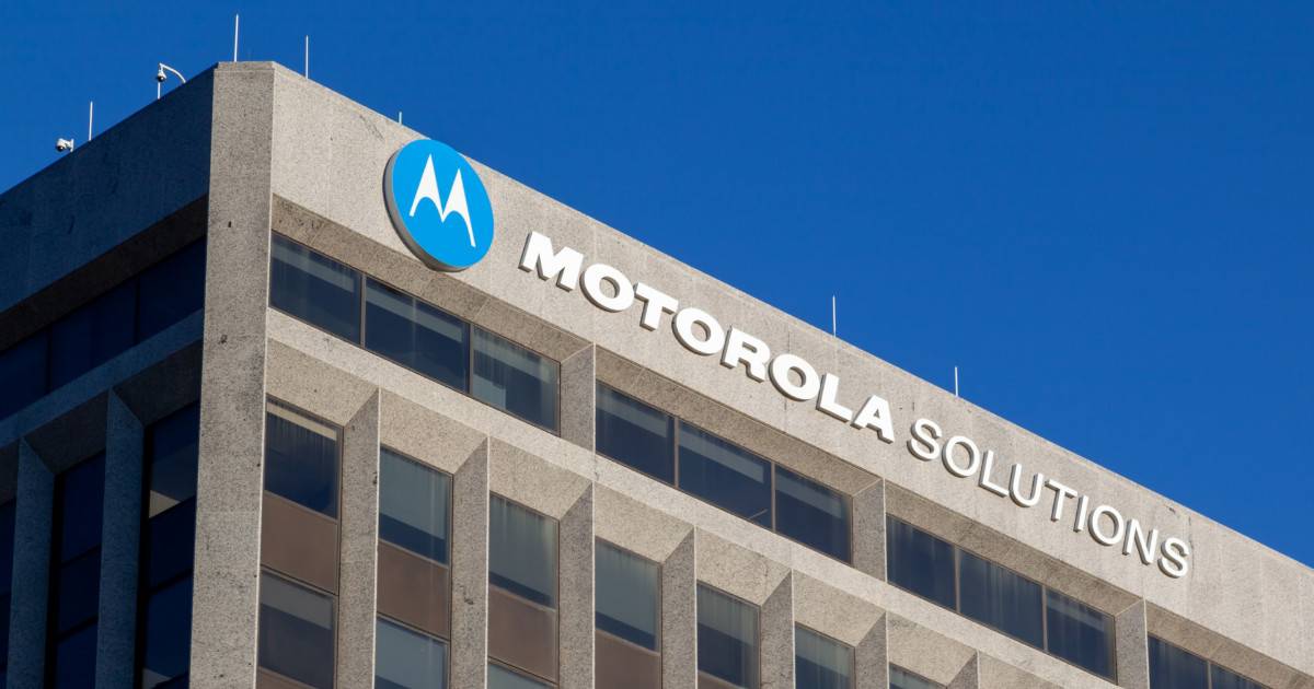 Fachada de um prédio corporativo com o logotipo da Motorola Solutions em destaque, sobre um céu azul claro