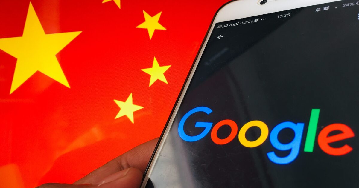 Imagem de um smartphone exibindo o logotipo do Google na tela, segurado por uma mão, com a bandeira da China ao fundo. A composição sugere uma relação entre o Google e a China.